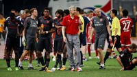 Wenger memadukan sepatu itu dengan gaya pakaian yang kasual. Atasan kaos kerah merah Arsenal, dan celana training abu-abu. (Damir Sagolj/Reuters)