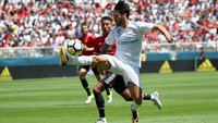 Isco mengontrol bola dengan dibayang-bayangi oleh Jesse Lingard. Foto: Ezra Shaw/Getty Images