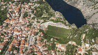 Berada di Kroasia, Stadion Gospin Dolac berdiri di tepi jurang yang di bagian bawahnya terdapat semacam danau. Hijau rumput stadion mencolok di antara rumah yang mengelilingi. (Instagram @upoznajmoohrvatsku)
