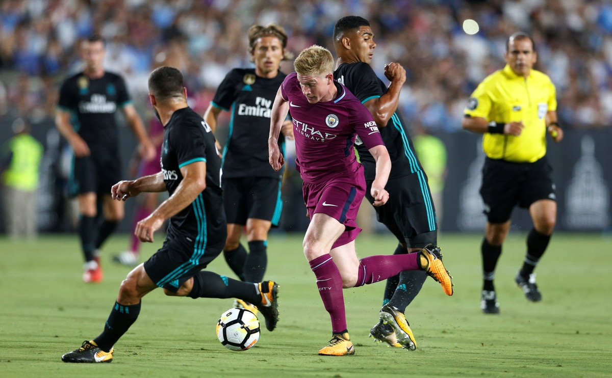 Kevin de Bruyne di tengah kerumunan pemain Real Madrid. Foto: REUTERS/Lucy Nicholson