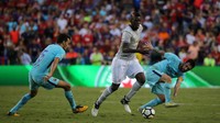 Paul Pogba head-to-head dengan Sergio Busquets. Lionel Messi juga membantu untuk merebut bola dari penguasaan pemain termahal dunia itu.