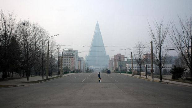 A traffic warden is seen from the window of a bus as he stands on an empty street before the Ryugyong Hotel in Pyongyang on April 12, 2012. North Korea's five-day window to launch a rocket opened with Asian countries on alert, as Washington told G8 world powers that the communist state was in flagrant violation of a UN ban.    AFP PHOTO / Ed Jones / AFP PHOTO / Ed Jones
