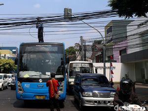 Aksi Petugas TransJ Atasi Kabel Melintang di Jalan