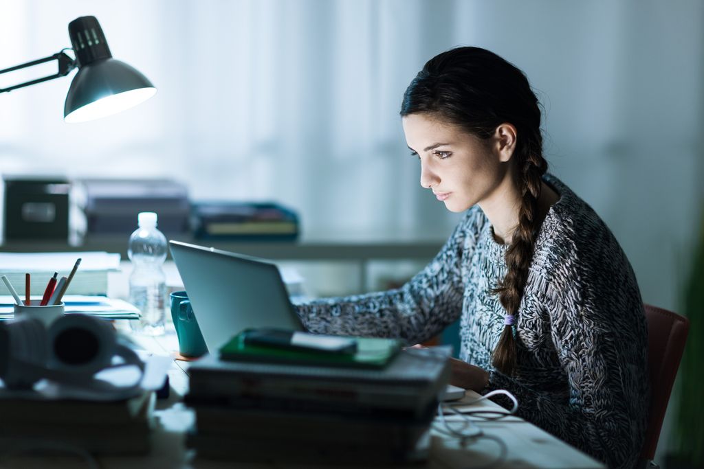 Business woman drinking coffee to get some energy for working overtime