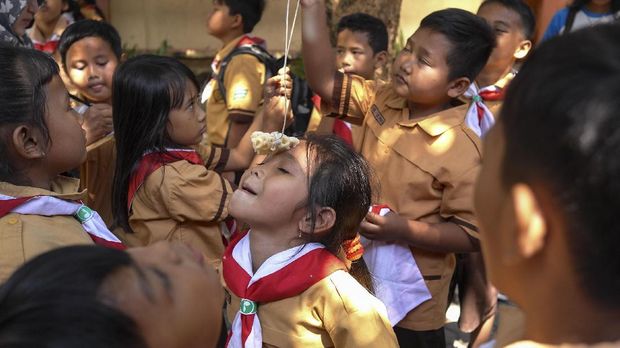 Sejumlah siswa SD Mangkuyudan, Solo mengikuti lomba memakan kerupuk di sekolah setempat, Solo, Jawa Tengah, Senin (14/8). Lomba tersebut digelar sebagai perayaan Hari Pramuka sekaligus menyambut HUT Ke-72 RI. ANTARA FOTO/Maulana Surya/pd/17.