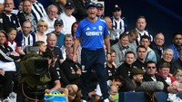 Topi, tracksuit, dan sepasang sepatu kets jadi pilihan Manajer West Bromwich Albion Tony Pulis. Satu lagi penampilan klasik dari pelatih, walaupun takkan jadi pilihan semua orang. (Foto: Hannah McKay/Reuters)