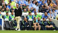 Manajer Manchester City Pep Guardiola tampil bergaya dengan paduan sweater warna gelap yang dipadukan dengan kemeja terang dan celana chinos. Sepatu yang ia kenakan melengkapi penampilannya yang chic. (Foto: Hannah McKay/Reuters)