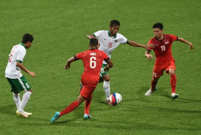 Indonesias midfielder Zulfiandi Zulfiandi (2nd R) dribbles the ball past Singapore players Anumanthan Mohan Kumar (2nd at L) and Stanely Ng Yong Woo in their football first round group A match at the 28th Southeast Asian Games (SEA Games) in Singapore on June 11, 2015. AFP PHOTO / ROSLAN RAHMAN / AFP PHOTO / ROSLAN RAHMAN