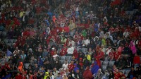 Hujan yang mengguyur stadion tak mengurangi antusiasme suporter. Foto: Michael Dalder/REUTERS