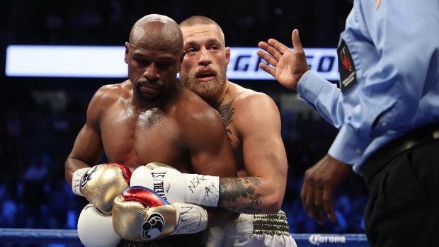 LAS VEGAS, NV - AUGUST 26: (L-R) Floyd Mayweather Jr. and Conor McGregor tie up during their super welterweight boxing match on August 26, 2017 at T-Mobile Arena in Las Vegas, Nevada.   Christian Petersen/Getty Images/AFP