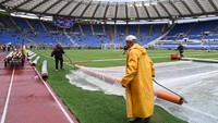 Setelah cuaca membaik, penutup lapangan mulai dibuka dan kick-off pertandingan dilakukan pukul 21.00 WIB. Foto: Alberto Lingria/REUTERS