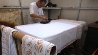 Seorang perajin mencetak kain batik khas Betawi menggunakan malam atau lilin yang dipanaskan di kawasan Terogong, Cilandak, Jakarta.