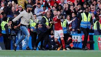 Akibat tindakan menyusup ke lapangan itu pun fans tersebut langsung ditangkap petugas keamanan dan dikeluarkan dari stadion. Ia tak bisa menyaksikan 15 menit sisa laga, gara-gara merayakan sebuah gol yang bahkan tak sah. (Foto: Eddie Keogh/Reuters)