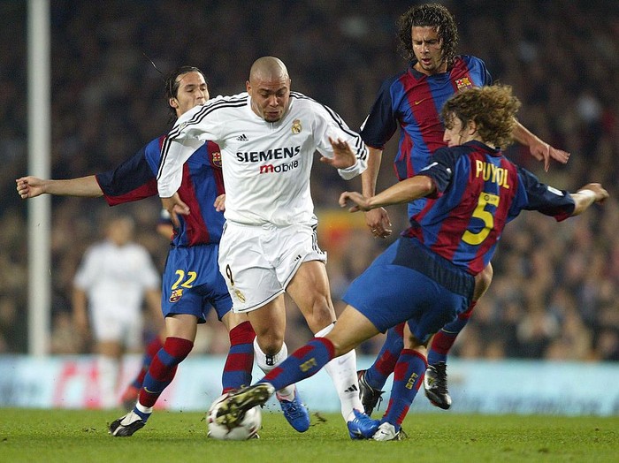BARCELONA, SPAIN - DECEMBER 6:  Ronaldo of Real Madrid is challenged by Puyol, Motta and Luis Garcia of Barcelona during the Spanish Primera Liga match between Barcelona and Real Madrid at the Nou Camp Stadium on December 6, 2003 in Barcelona, Spain.  (Photo by Shaun Botterill/Getty Images)