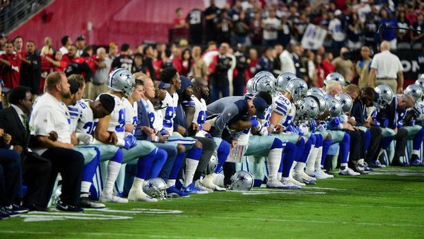 Atlet Dallas Cowboys berlutut saat lagu kebangsaan Amerika Serikat berkumandang.