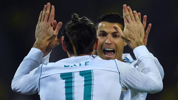 Real Madrid's forward from Portugal Cristiano Ronaldo celebrates scoring with Real Madrid's forward from Wales Gareth Bale during the UEFA Champions League Group H football match BVB Borussia Dortmund v Real Madrid in Dortmund, western Germany on September 26, 2017. / AFP PHOTO / Patrik STOLLARZ