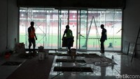 Tiga orang pekerja menyelesaikan salah satu ruangan di dalam Stadion Utama GBK.