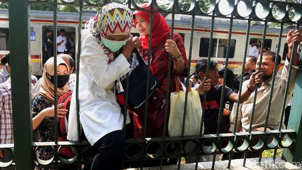Foto: Dampak Anjlok, Penumpang KRL Nekat Naik Pagar Tinggi