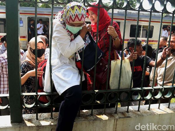 Foto: Dampak Anjlok, Penumpang KRL Nekat Naik Pagar Tinggi