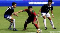 Firza Andika berusaha melewati pengawalan dua pemain Kamboja.