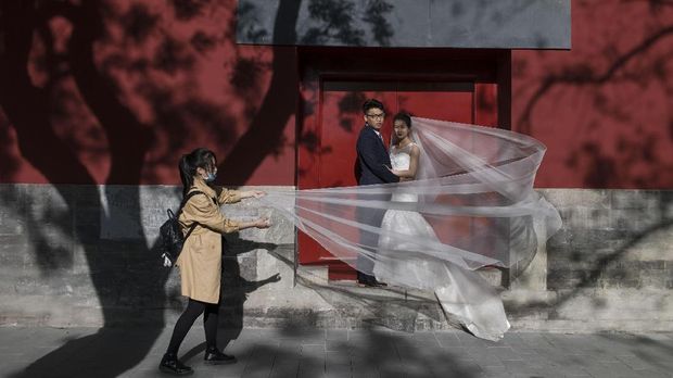 A couple poses for wedding photography near The Forbidden City on April 24, 2017, in Beijing. / AFP PHOTO / FRED DUFOUR