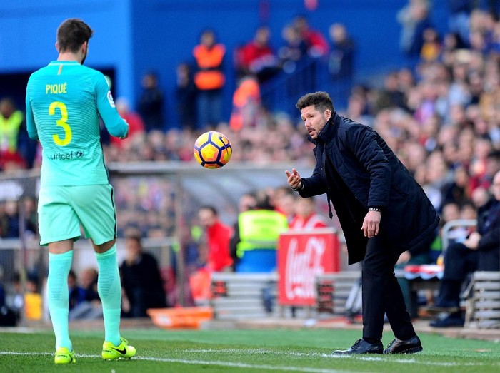 MADRID, SPAIN - FEBRUARY 26:  Head coach Diego Simeone of Club Atletico de Madrid throws the ball to Gerard Pique of FC Barcelona during the La Liga match between Club Atletico de Madrid and FC Barcelona at Vicente Calderon Stadium on February 26, 2017 in Madrid, Spain.  (Photo by Denis Doyle/Getty Images)