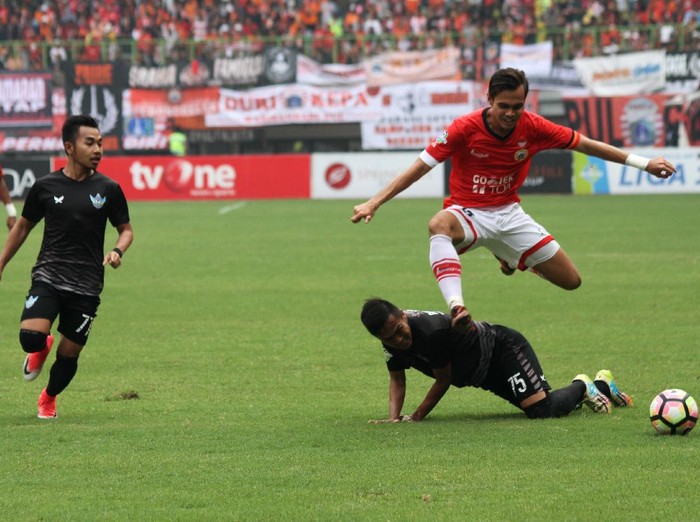 Pesepak bola Persija Jakarta M Rezaldi Hehanusa (atas) melompat melewati hadangan pesepak bola Persegres Gresik United Roni Rosadi (bawah) pada pertandingan Gojek Traveloka Liga 1, di Stadion Patriot Candrabhaga, Bekasi, Jawa Barat, Sabtu (14/10). Tuan rumah Persija mengalahkan Persegres Gresik United dengan skor 5-0. ANTARA FOTO/Risky Andrianto/kye/17
