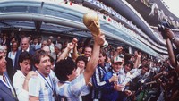 Maradona mengangkat trofi Piala Dunia 1986 usai mengalahkan Jerman Barat di pertandingan final (Mike King/ALLSPORT).