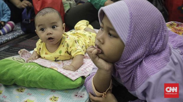 Peserta pijat bayi memijat anaknya saat kegiatan pijat bayi massal Kesehatan, Jakarta, Selasa, 7 November 2017. Dalam rangka memperingati di Kementerian tahun (Baduta) ikut dalam Hari Kesehatan Nasional ke-S3, Kementerian Kesehatan mengadakan pijat bayi massal banyak 300 bayi dibawah dua tahun ikut dalam kegiatan tersebut. CNNIndonesia/Adhi Wicaksono.