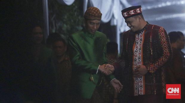 Joko Widodo (kiri) dan Bobby Nasution (kanan) bersalaman seusai acara midodareni Kahiyang Ayu, (7/11). (CNN Indonesia/ Hesti Rika)