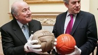 Bola yang dipegang mantan Presiden FIFA Sepp Blatter (kiri) ini merupakan bola yang dipakai di Piala Dunia pertama pada 1930 di Uruguay, namanya T-Model. Ada yang bisa menebak bola yang sebelah kanan untuk Piala Dunia edisi tahun berapa? (Foto: CARL DE SOUZA/WPA POOL/AFP PHOTO)
