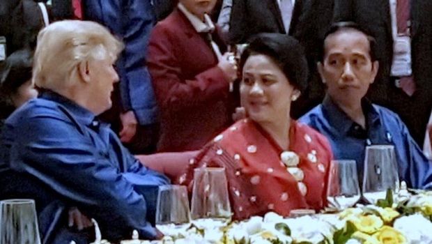 Presiden Jokowi memandangi Trump yang terus mengajak Iriana mengobrol. 