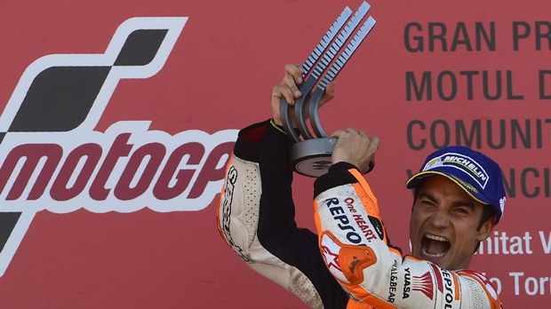 Repsol Honda Team's Spanish rider Dani Pedrosa celebrates on the podium after winning the MotoGP race of the Valencia Grand Prix at Ricardo Tormo racetrack in Cheste, near Valencia on November 12, 2017. Spain's Marc Marquez sealed his sixth world championship and fourth in the premier MotoGP category with third place at the Valencia Grand Prix. Marquez's Honda teammate Dani Pedrosa won the race from France's Johann Zarco in second. / AFP PHOTO / PIERRE-PHILIPPE MARCOU