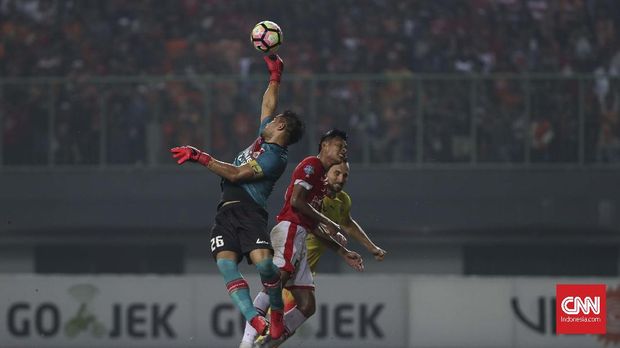 Andritany melakukan penyelamatan dengan menangkap bola yang meluncur ke gawang.