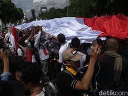 Massa PKS Bentangkan Bendera RI dan Palestina Raksasa ke Patung Kuda