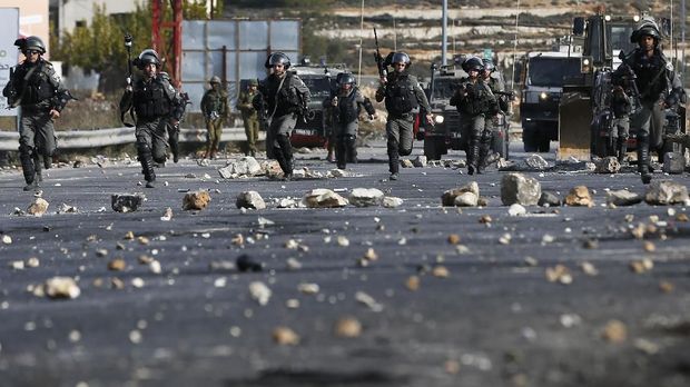 Israeli security forces clash with Palestinian protestors in the West Bank city of Ramallah on December 11, 2017 as demonstrations continue to flare in the Middle East and elsewhere over US President Donald Trump's declaration of Jerusalem as Israel's capital. / AFP PHOTO / ABBAS MOMANI