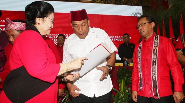 Ketua Umum PDIP Megawati Soekarnoputri (kiri) menyerahkan surat rekomendasi kepada pasangan bakal calon gubernur dan wakil gubernur Maluku Murad Ismail (tengah) dan Barnabas Orno (kanan) seusai mengumumkan bakal calon gubernur dan wakil gubernur empat daerah di DPP PDIP, Jakarta, Minggu (17/12). PDIP resmi mengusung pasangan Arsyadjuliandi Rachman-Suyatno pada Pilgub Riau, Asrun-Hugua pada Pilgub Sulawesi Tenggara, Marianus Sae-Emilia Nomleni pada Pilgub NTT, dan Murad Ismail-Barnabas Orno pada Pilgub Maluku. ANTARA FOTO/Rivan Awal Lingga/ama/17