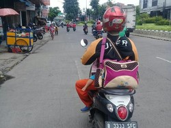 Kata Uber Soal Foto Viral Driver Ojek Narik Sambil Gendong Anak