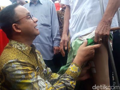 Foto: Saat Anies Pasangkan Kaki Palsu ke Lansia di Monas