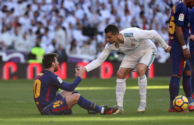 Soccer Football - La Liga Santander - Real Madrid vs FC Barcelona - Santiago Bernabeu, Madrid, Spain - December 23, 2017   Real Madrid's Cristiano Ronaldo helps Barcelona's Lionel Messi get back to his feet   REUTERS/Sergio Perez