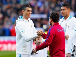 Cristiano Ronaldo mengedipkan satu matanya saat berjabat tangan dengan Lionel Messi sebelum kick off. Laga El Clasico di akhir pekan kemarin menjadi ajang unjuk kemampuan dua pemain yang dikliam sebagai GOAT (greatest of all time) (Gonzalo Arroyo Moreno/Getty Images)