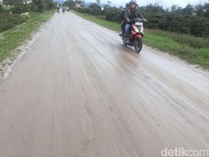 Petugas Bersihkan Jalan yang Terkena Abu Vulkanik Gunung Sinabung