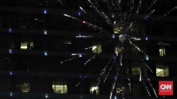 Jakarta Berpesta Sambut Tahun Baru 2018 Warga menyaksikan pesta kembang api saat malam pergantian tahun baru 2018 di kawasan Bundaran HI, Jakarta 1 Januari 2018. (CNN Indonesia/ Adhi Wicaksono)