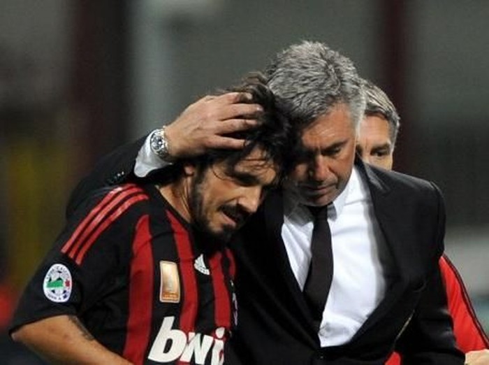 AC MIlan's midfielder Gennaro Gattuso (L) leaves the pitch flanked by AC Milan's coach Carlo Ancelotti during their   