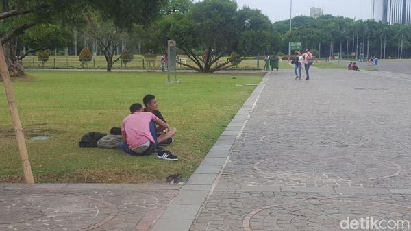 Foto: Saat Warga Duduk-duduk di Rumput Monas yang Tanpa Pagar