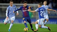 Lionel Messi berusaha melewati David Zurutuza dan Kevin Rodrigues dalam lanjutan La Liga di Estadio Anoeta. Vincent West/Reuters.