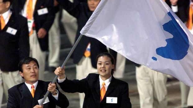 Atlet Korut Jang Choo Pak (kiri) dan atlet Korsel Eun-Soon Chung mengibarkan bendera unifikasi Korea di Olimpiade Sydney, Australia, 15 September 2000.