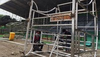 Di sisi lintasan lapangan tampak rangka-rangka untuk tempat duduk pemain (bench), juga area teknis wasit dan ofisial pertandingan.