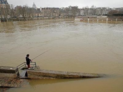 Foto: Paris Banjir, Pria Ini Malah Asyik Memancing di Sungai Seine