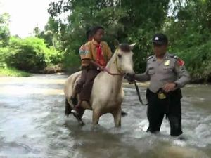 Dengan Kudanya, Polisi Ini Bantu Siswa Seberangi Sungai